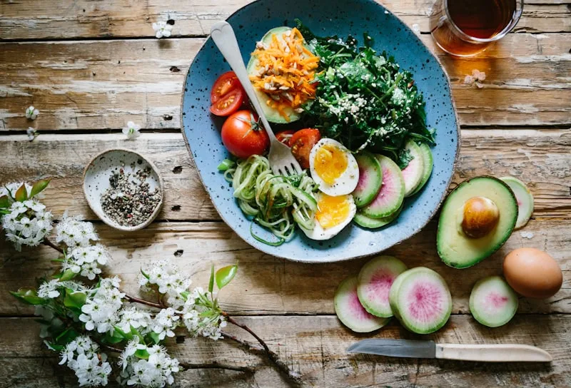 Prato de comida de verdade com folhas verdes, tomate, ovo e abacate